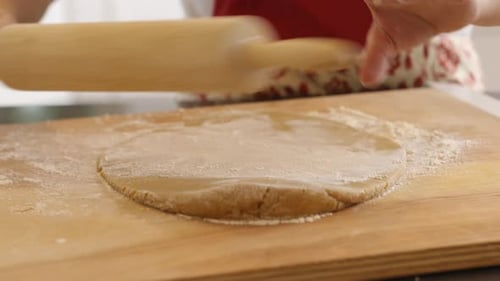 Using rolling pin to roll cookie dough