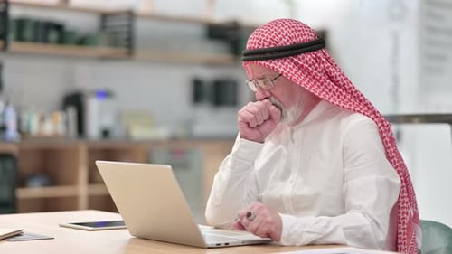 Senior Man Using Laptop at Workplace