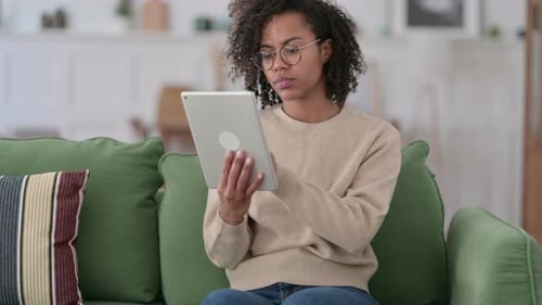 Woman Using Tablet on Couch at Home