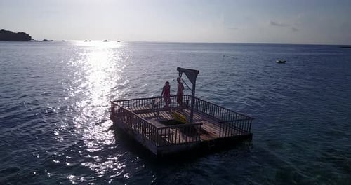 Beautiful people on honeymoon vacation enjoy luxury on beach on sunny white sandy