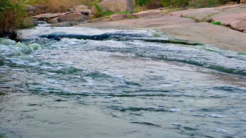 A Small Shining Stream Flows Among Smooth Wet and Dark Stones