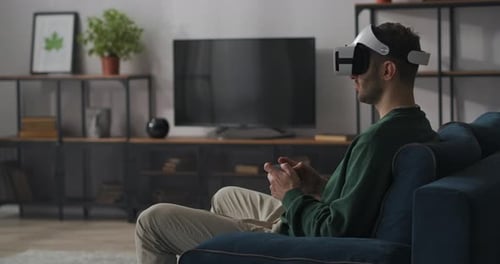 Man Using VR Headset and Controller on Couch