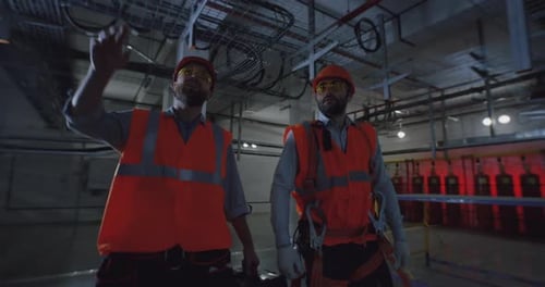 Trabajadores varones caminando y hablando en la fábrica