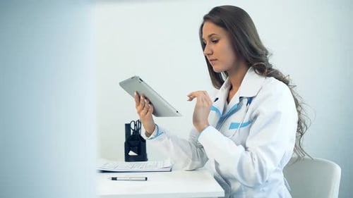 Female Doctor Using Tablet Computer in Medical Office