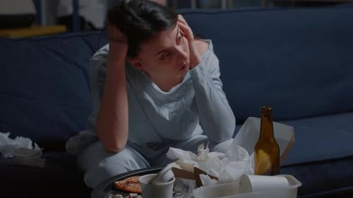Sad Young Woman Sitting Near Messy Coffee Table