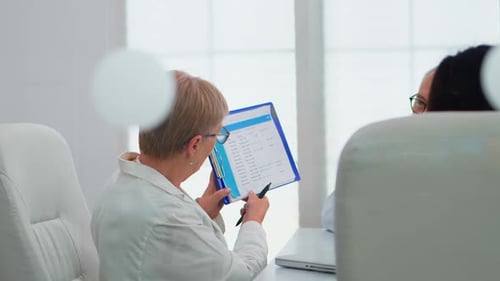 Doctor Reviews Records in Bright Office Setting