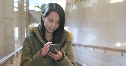 Woman Using Smartphone in Urban Tunnel
