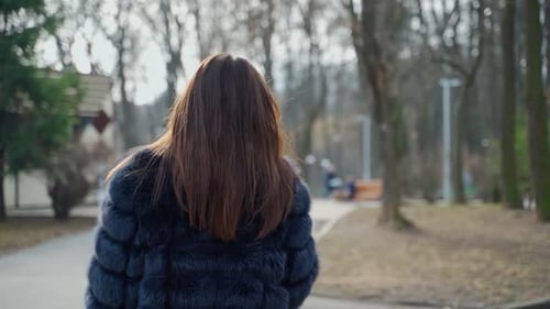 Elegant Woman in Fur Coat Walking in Park