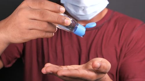 Close Up of Young Man Hand Using Sanitizer Gel for Preventing Virus
