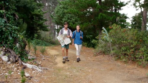 Adults Hiking with Map and Compass in Forest