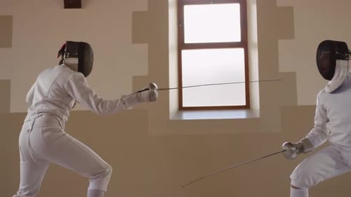 Fencer athletes during a fencing training in a gym
