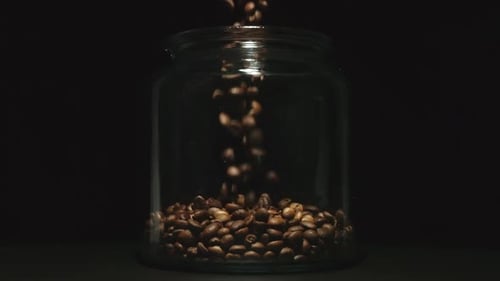 Coffee Beans Pouring Into Glass Jar