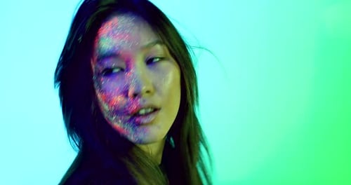 Woman with Glitter Makeup Posing in Colorful Light