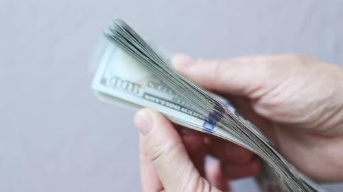 Shuffling Stack Pack of Hundred 100 Dollar Bills on Light Grey Background