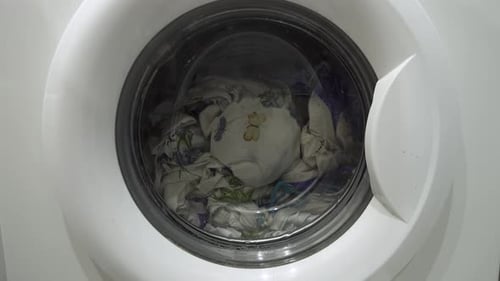 Washing Machine Loads Clothes in Household Appliance