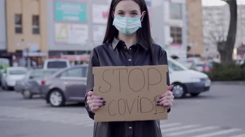 Young Woman Holding Sign in Urban Environment