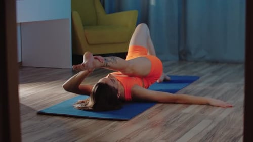 Woman Practicing Yoga on Mat at Home