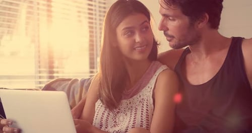Smiling Couple Using Laptop Together at Home