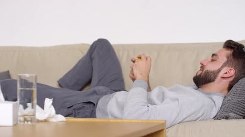 Handsome Man Throwing Tennis Ball against Wall