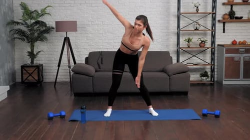 Fit Woman Stretching on Yoga Mat at Home
