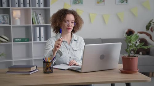 Woman Working from Home on Laptop Taking Notes
