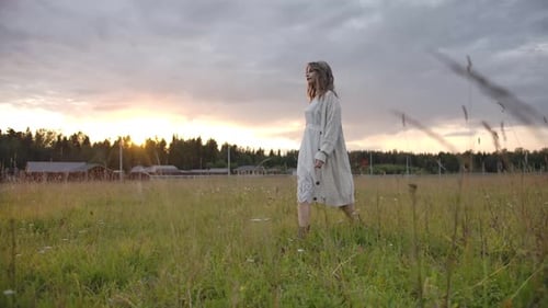 Sensual Woman in White Dress Walking in Field Near Farm