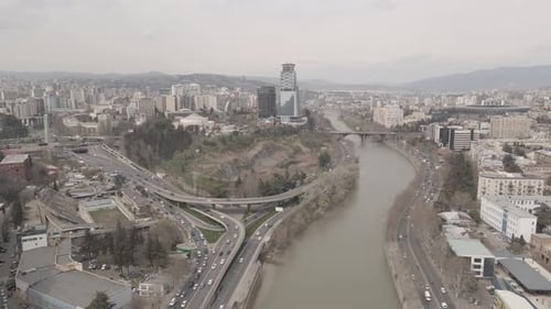Flying over Kura river in Tbilisi. Beautiful aerial view of Baratashvili bridge