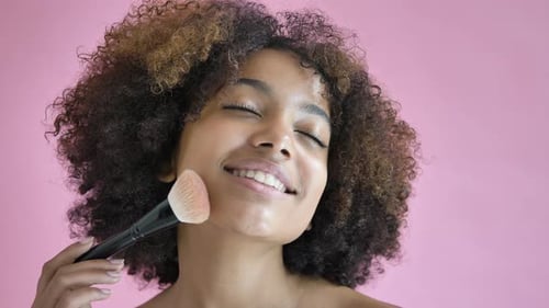 Experienced Model Poses Applying Cosmetic Powder on Face