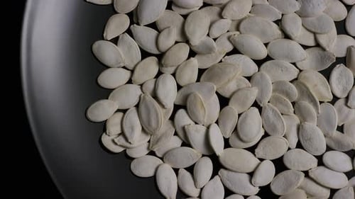 Pumpkin Seeds Piled on a Dark Gray Plate