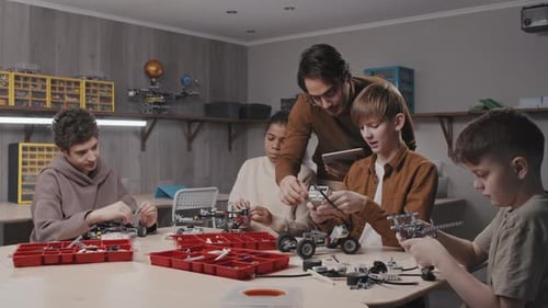 Teacher Helping Students With Robotic Models