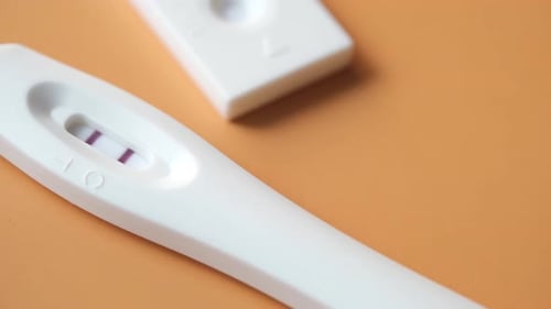 Pregnancy Test Kit with Positive Result on Color Background