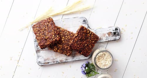 Squares of Oat Bars Stacked on Cutting Board
