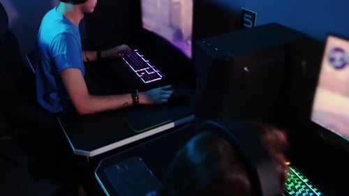 Online Gaming a Group Og Three Friends Sitting in the Gaming Club and Having an Online Shooter Game