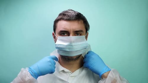 Man in Protective Suit Putting on Mask and Bonnet