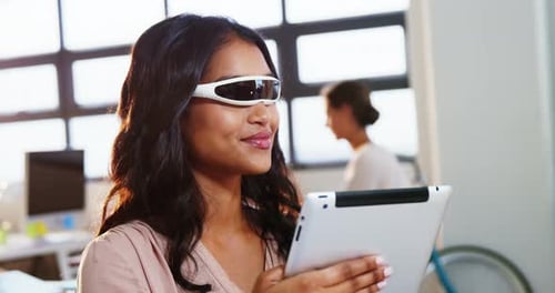 Woman Using Tablet with Modern Glasses in Office