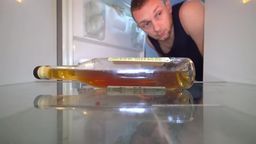 Man Reaches into Empty Refrigerator for Bottle
