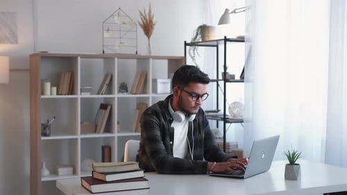 Young Adult Working on Laptop at Desk