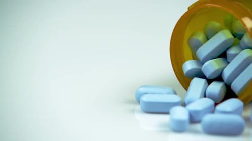 Blue Pills Spilling from Bottle