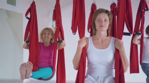 Women Doing Aerial Yoga in a Gym