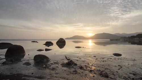 Calm Beach at Sunrise with Rock Formations