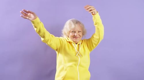 Slow Motion an Elderly Woman Listens To Music and Dances in Studio.