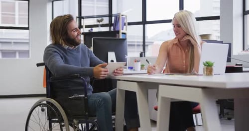 Man in Wheelchair Collaborates With Colleague at Workplace