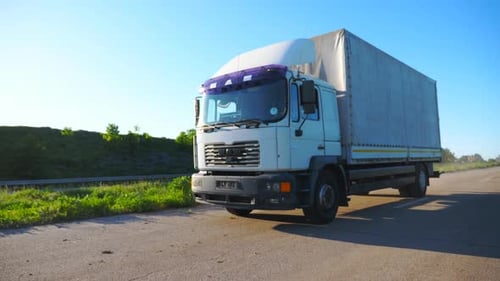 Camera Follows to Truck with Cargo Trailer Driving on Highway and Transporting Goods