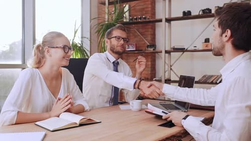 Business People Concluding Deal with Handshake in Office