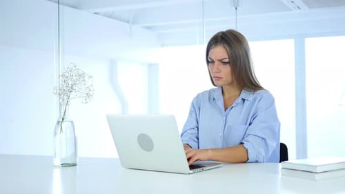 Woman Typing on Laptop at White Desk