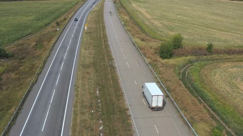 Aerial View of Truck with Cargo Trailer Driving on Straight Road and Transporting Goods. Camera