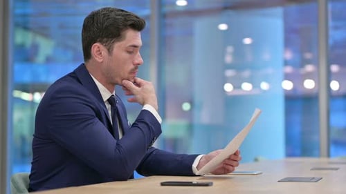 Businessman Reading Documents, Doing Paperwork in Office