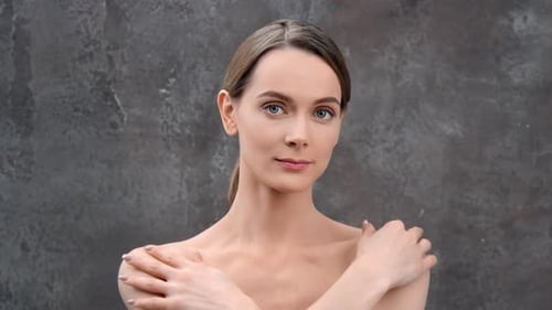 Elegant Young Woman Posing in Front of Grey Background