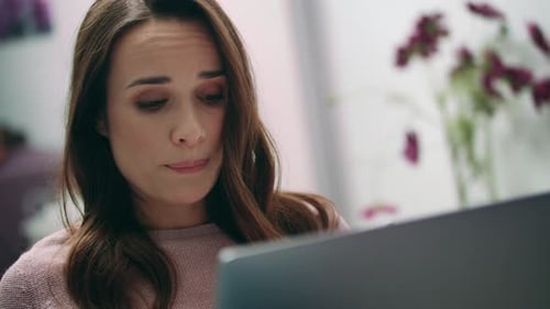 Müde Frau mit Blick auf Laptop-Bildschirm