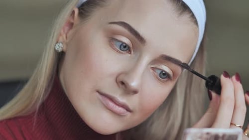 Young Woman Applying Eyebrow Makeup with Brush